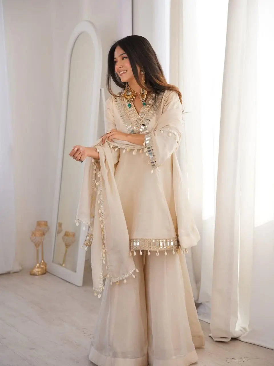 Women's Off-White Silk Blend Sharara Suit Set – Short Peplum Kurta with Heavy Mirror Work V-Neck & Shell Tassels – Designer Ethnic with Dupatta – Cream/Ivory Desi Diva