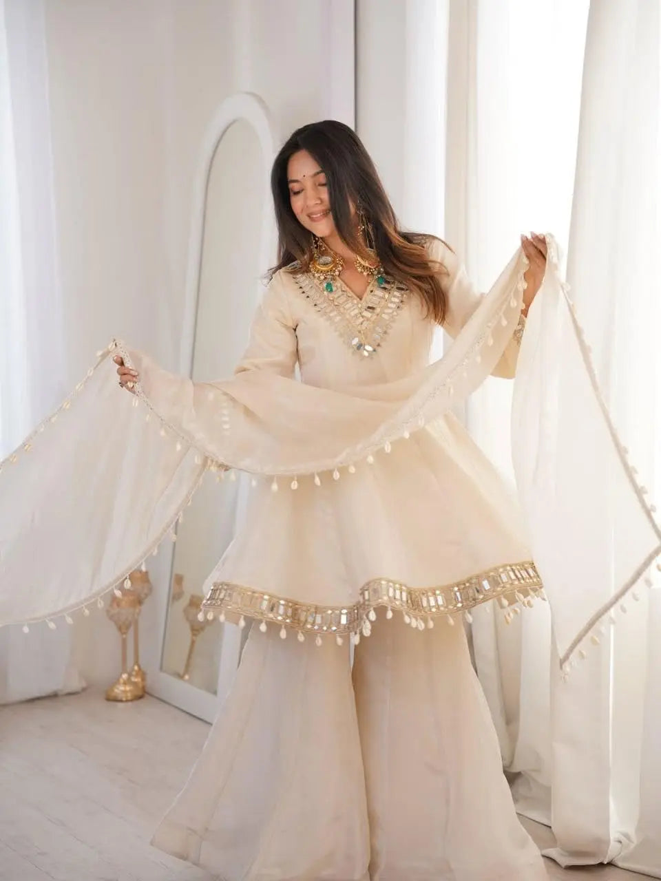Women's Off-White Silk Blend Sharara Suit Set – Short Peplum Kurta with Heavy Mirror Work V-Neck & Shell Tassels – Designer Ethnic with Dupatta – Cream/Ivory Desi Diva